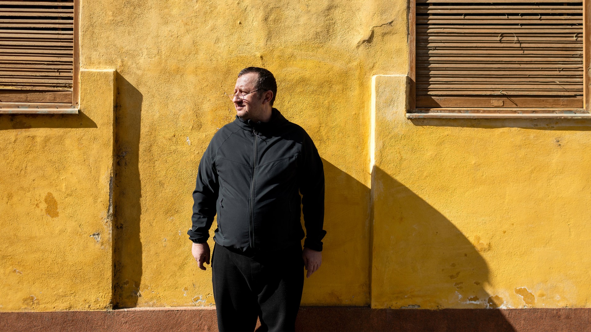 Dmitro Isaeiv standing in front of a yellow wall.