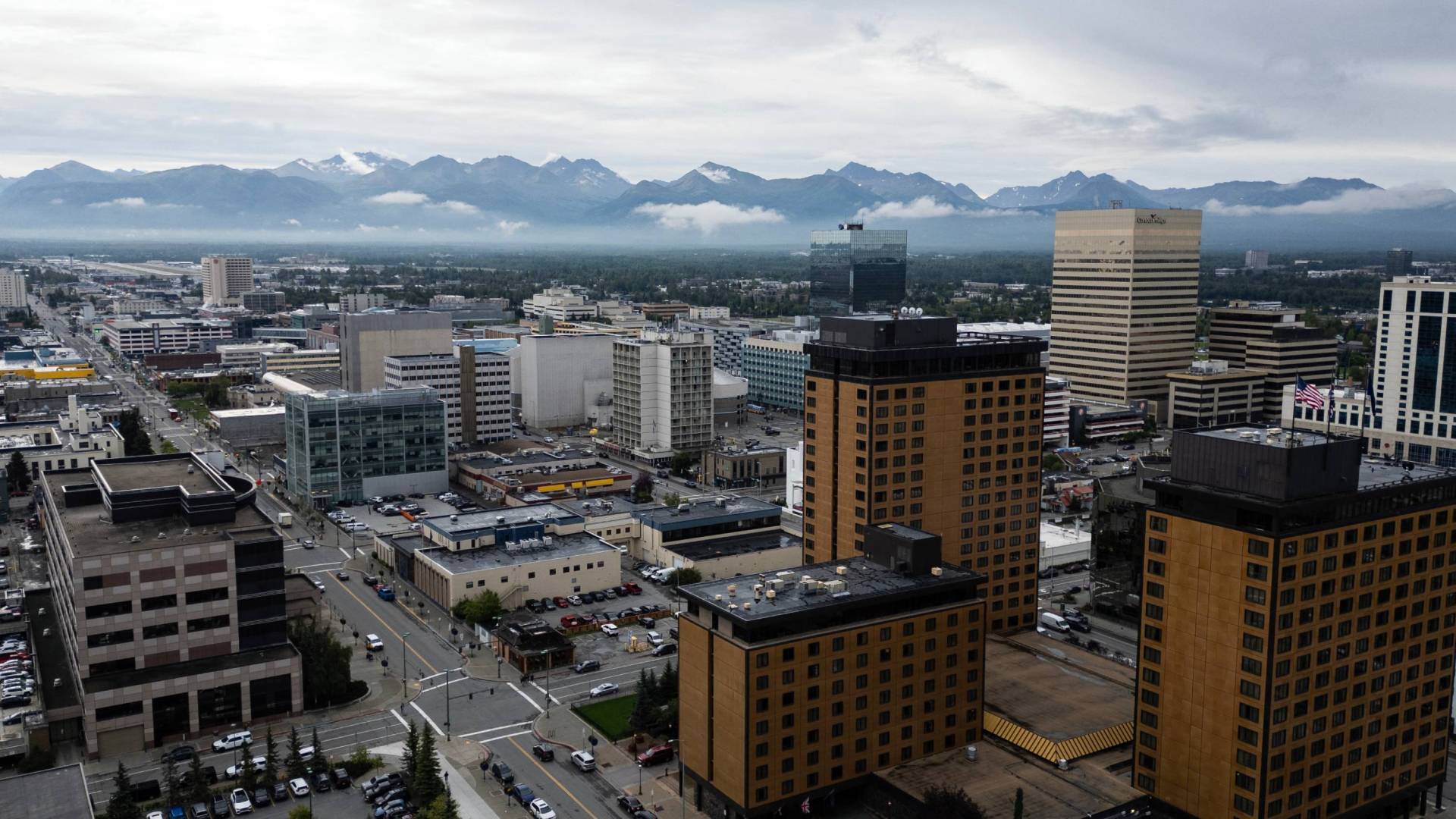 An aerial view of downtown Anchorage, Alaska, with the Chugach Mountains in the background