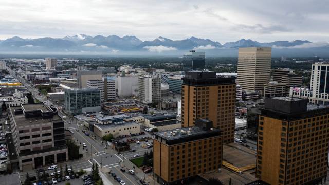 An aerial view of downtown Anchorage, Alaska, with the Chugach Mountains in the background
