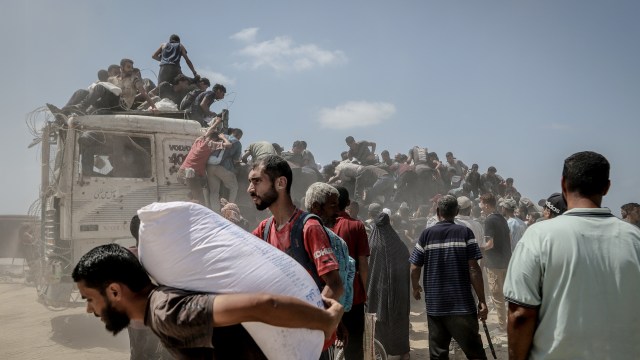 Palestinians struggling with severe food shortages amid ongoing Israeli attacks gather to receive limited aid supplies in northwestern Gaza.